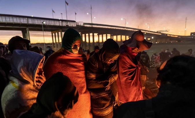 Migrants warm up around a campfire, U.S., Dec. 26, 2022.