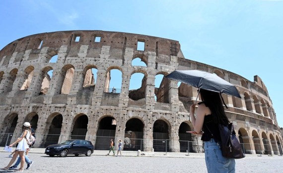 A woman shelters from the sun with umbrella during hot weather at the Colosseum in Rome, Italy, June 17, 2022.