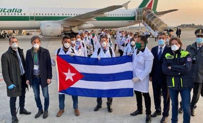 Cuban doctors hold their country's national flag, Italy.