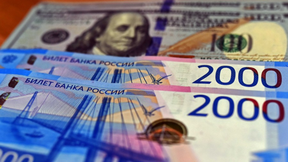 Russian ruble banknotes are seen with the U.S. dollars in the backdrop on March 2, 2021.