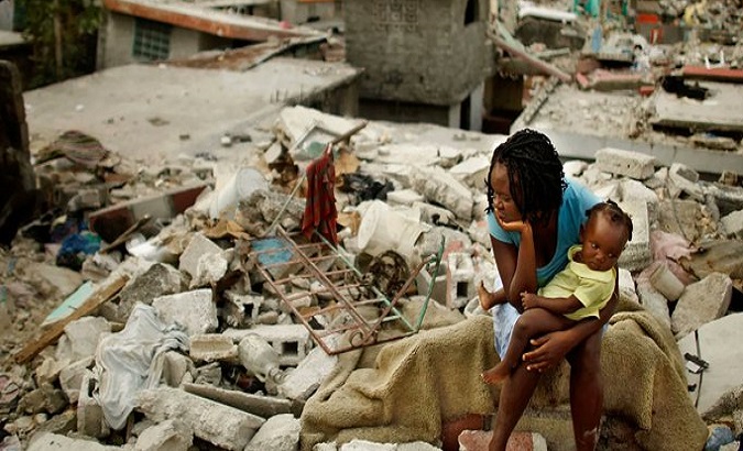 A woman sits next to her baby after the earthquake, Haiti.