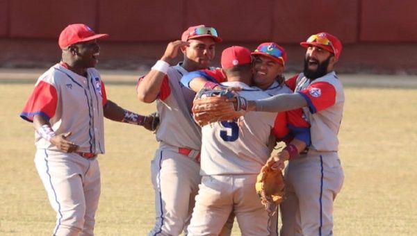 Baseball players embrace after winning a match, Cuba. 