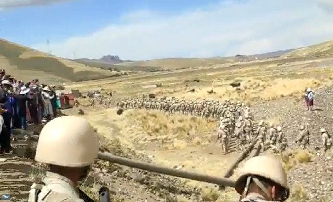Indigenous people watch the advance of a battalion through the highlands, Puno, Peru, Jan. 24, 2023.
