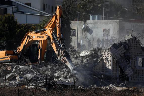 People operate excavators to demolish a house in the West Bank city of Hebron, on Jan. 11, 2023.