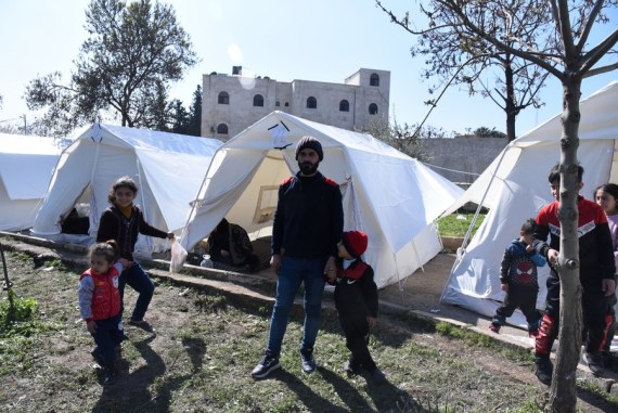 Displaced people are seen outside temporary tents in Aleppo, Syria, on Feb. 15, 2023.