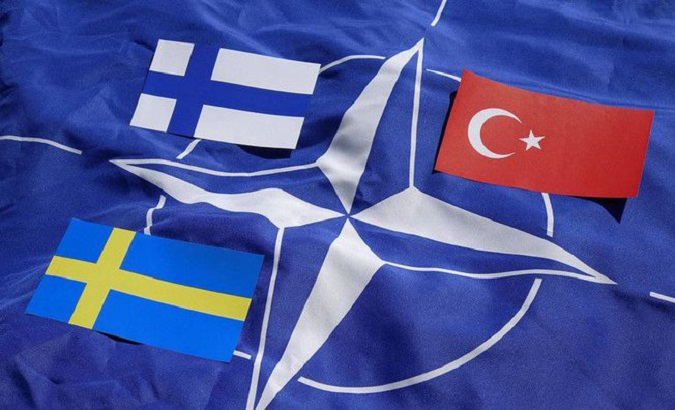 The flags of Finland, Türkiye, and Sweden (clockwise) on the NATO flag.