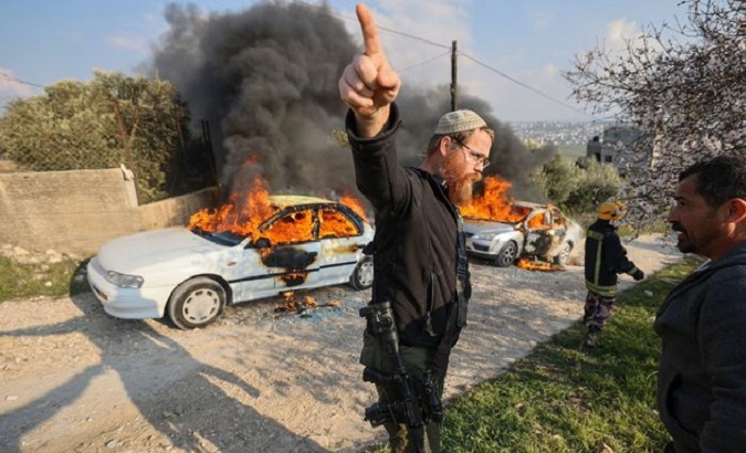 An armed Israeli settler intimidates a Palestinian, Feb. 26, 2023.