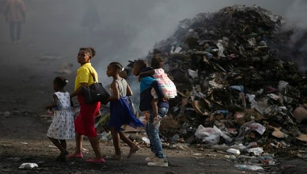 A Haitian family walks through an area devastated by violence, Haiti. 