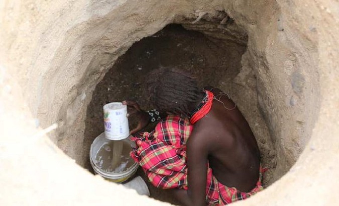 Pastoralist woman searching for water at a well in Kenya.