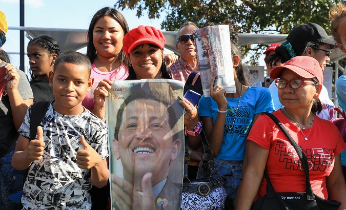 A Venezuelan citizen holds a photograph of the late President Hugo Chavez, 2023.