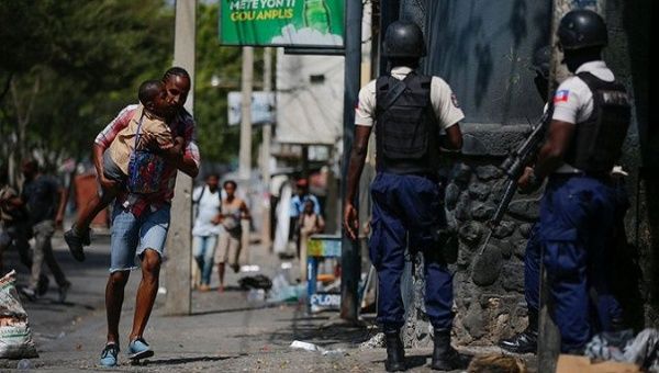 A father carries his son amid a police operation against gangs in Port-au-Prince, Haiti, March 3, 2023. 