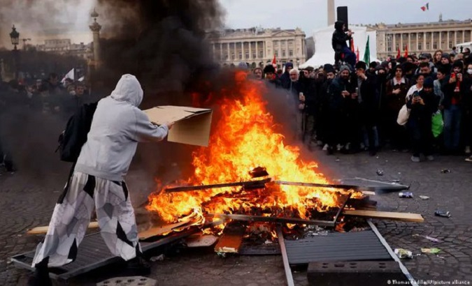People light garbage during protests in Paris, March 16, 2023.