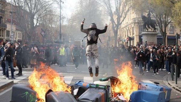 A protester sets garbage cans on fire, France. 