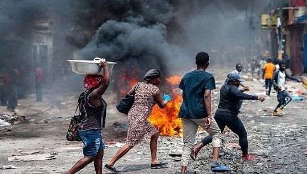 Haitians walk down a street attacked by gangs. 