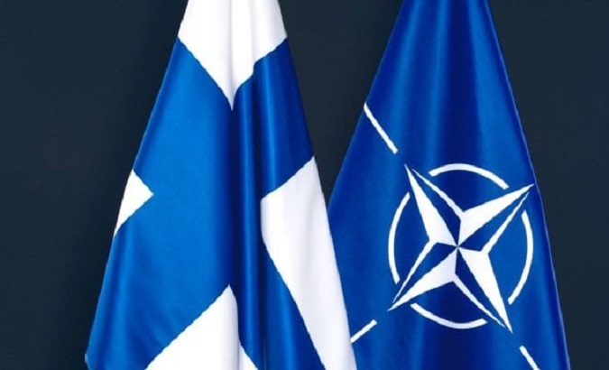 The flag of Finland (L) & the NATO flag (R).