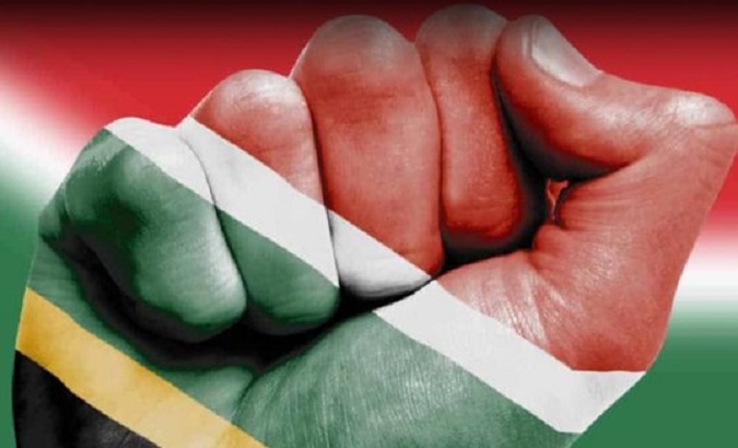 The South African flag projected onto a raised fist.