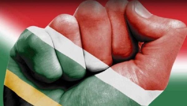 The South African flag projected onto a raised fist.