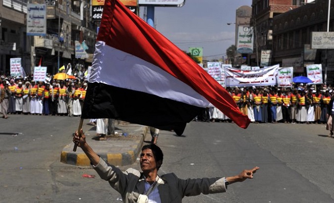Yemen employee holding Yemen's flag. May. 16, 2023.