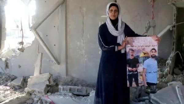 A woman holds a photo of Kamal Jouri at his home, June 22, 2023.
