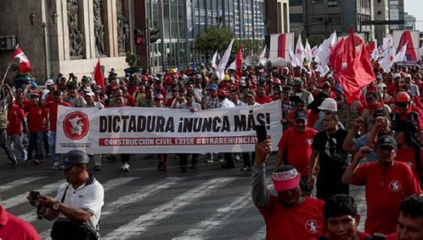 Peruvian workers hold a banner that reads, 