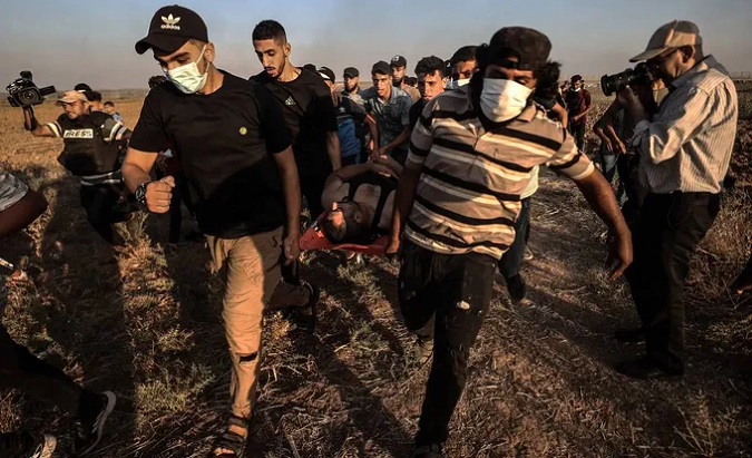 People carry an injured Palestinian, Sept. 24, 2023.