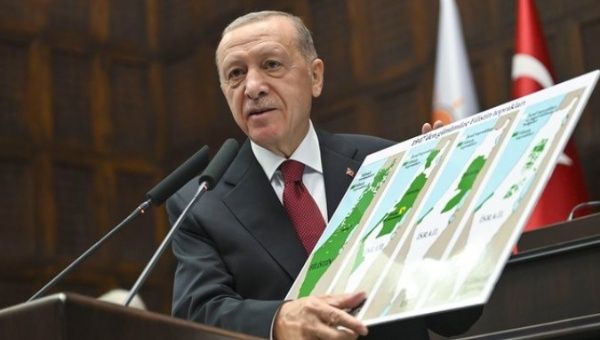 President Recep Tayyip Erdogan holds a map showing the reduction of Palestinian territory over time.