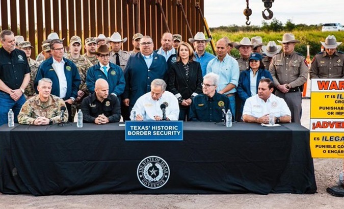 Texas Governor Greg Abbott (C) signing the bill, Dec. 18, 2023.