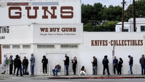 People wait for the opening of a weapons store.