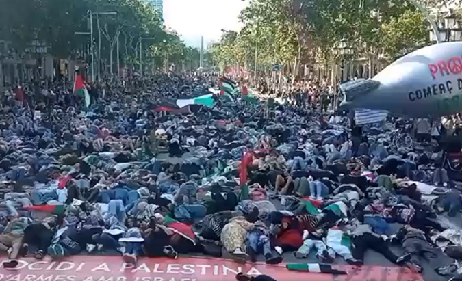 Hundreds of people throw themselves on the ground in Barcelona to represent the genocide in Gaza, May 22, 2024.,