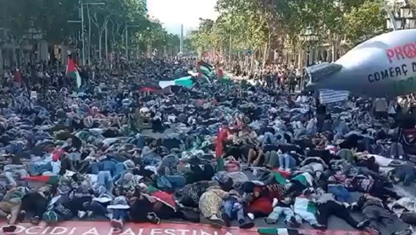 Hundreds of people throw themselves on the ground in Barcelona to represent the genocide in Gaza, May 22, 2024.,