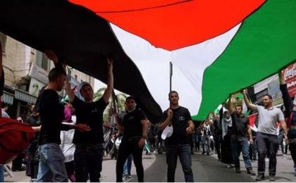 People hold a giant Palestinian flag, 2024.