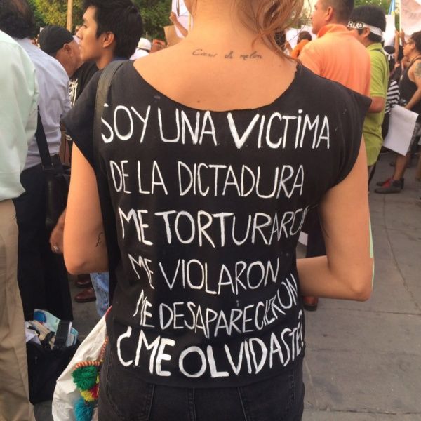 A protester wears a shirt describing her abuse under the Fujimori government.